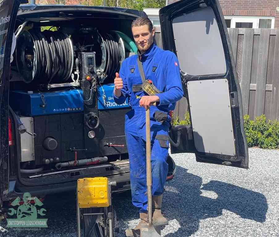 Een tevreden monteur met opgestoken duim naast de bestelbus, slim ingrijpen bespaart kosten bij een verstopte afvoer in Leidschendam