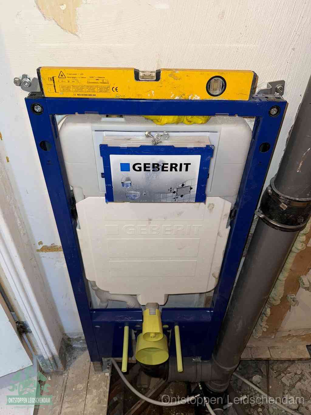 Een Geberit inbouwreservoir met frame voor een hangtoilet tegen de wand, met de afvoerbocht naar de vloer, kenmerkend voor een verstopt hangtoilet in Leidschendam