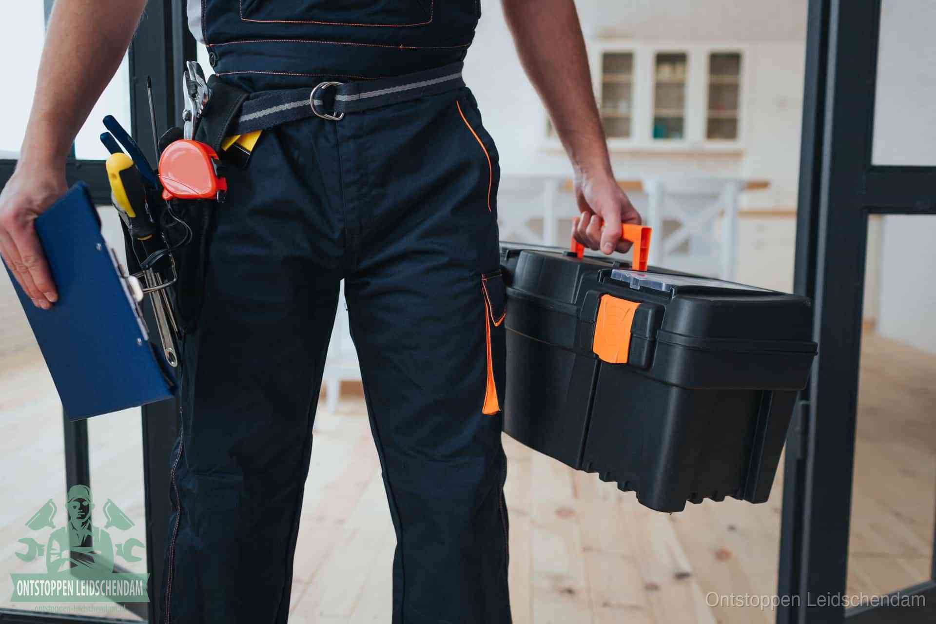 Een monteur met gereedschapsriem en klembord, klaar om een transparante prijs voor het afvoer ontstoppen in Leidschendam te geven
