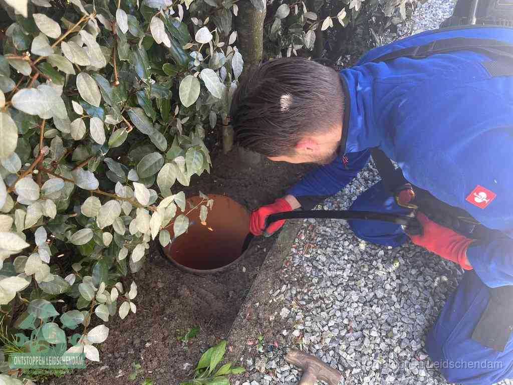 Monteur reinigt een rioolput met een slang, periodieke rioolreiniging in Leidschendam