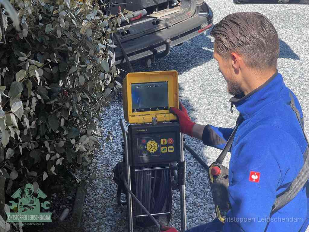Monteur bedient een rioolinspectiecamera met monitor voor rioolinspectie in Leidschendam