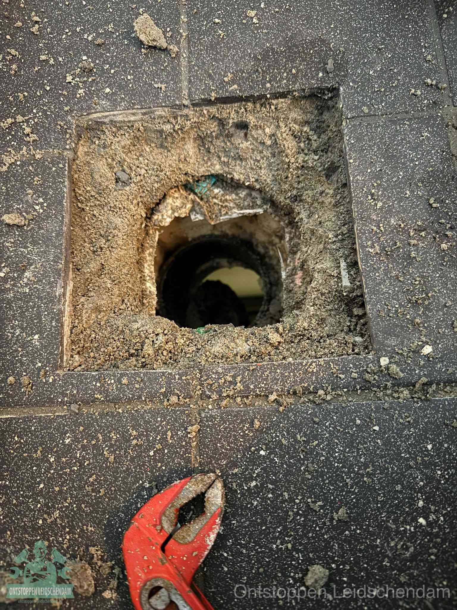 Geopend rioolputje op de erfgrens dat laat zien wie eigenaar is van de riolering in Leidschendam