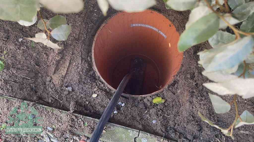 Open inspectieput in de tuin waar een veer rioolvliegjes en stankoverlast aanpakt in Leidschendam