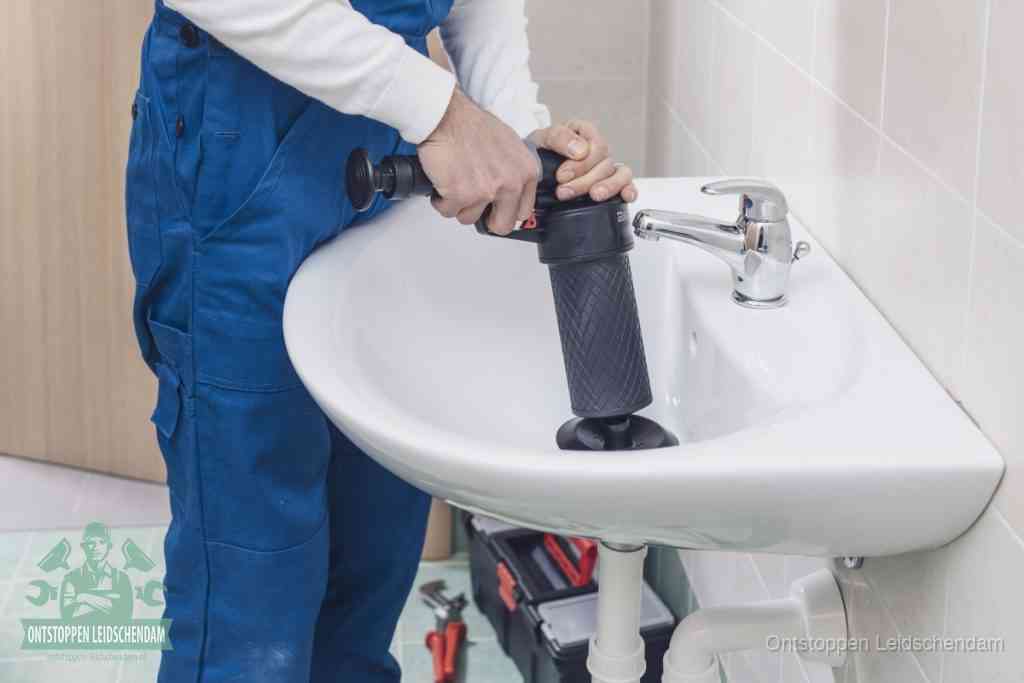 Een te ruwe doe-het-zelf poging met een hand-pomp op de afvoer van een badkamer-wastafel, een van de veelgemaakte fouten bij afvoer ontstoppen in Leidschendam