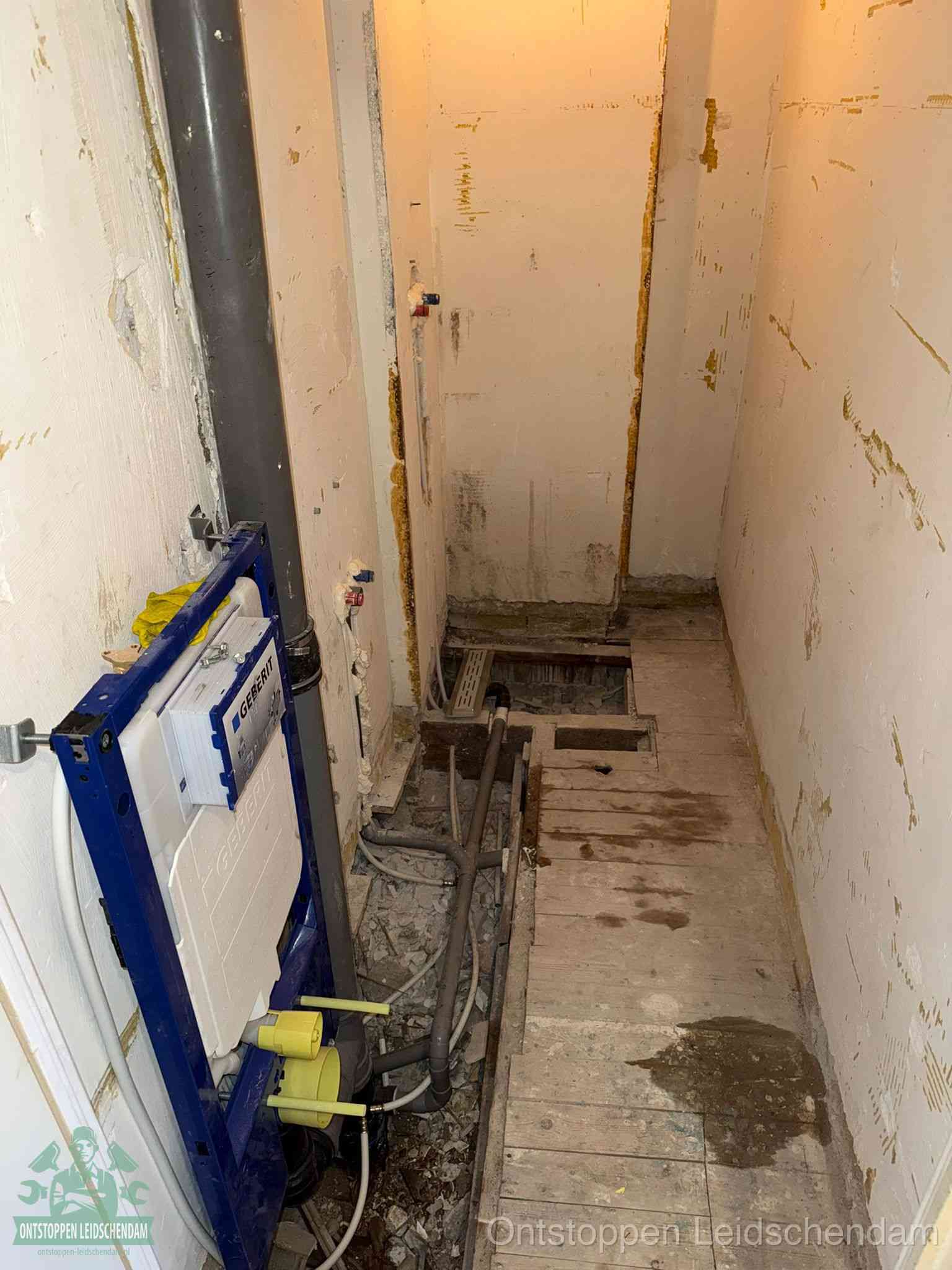 Een opgebroken toiletruimte tijdens renovatie met een Geberit inbouwreservoir en blootliggende oude afvoerleidingen, typisch voor oudere woningen in Leidschendam