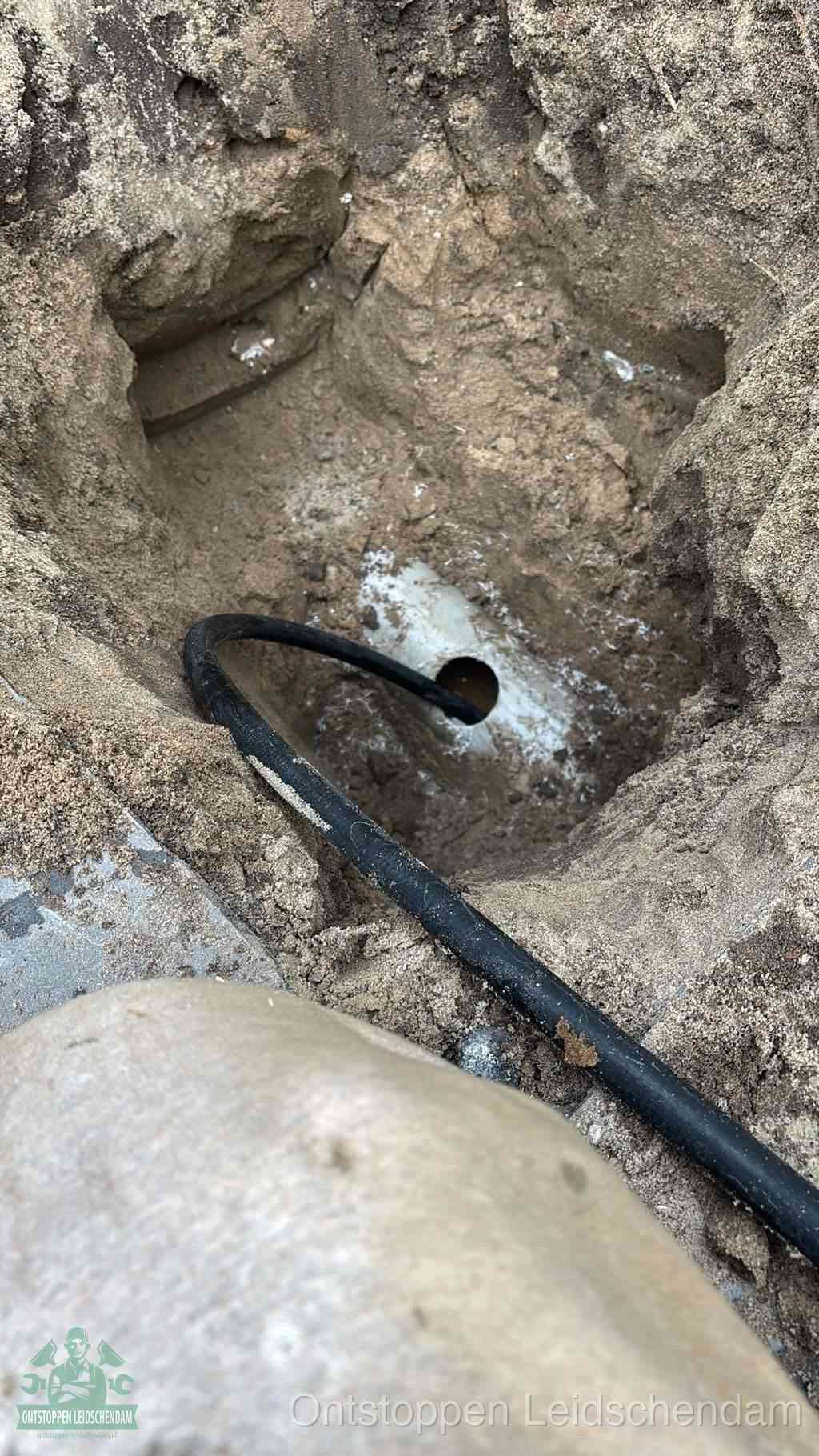 Uitgegraven rioolbuis in de grond, hulp om zelf het riool te ontstoppen in Leidschendam